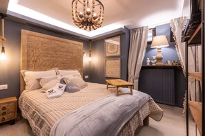 A bedroom with a large bed, a bedside table, a nightstand, a ceiling light fixture, and a radiator. - Rock Dandy La Maison De L’Ours | Top Fireplace Retreat (Amyntaio)