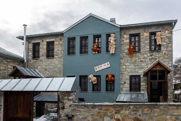 A stone building with multiple windows and a sign that reads "Fresh cut Christmas trees." - Rock Dandy La Maison De L’Ours | Top Fireplace Retreat (Amyntaio)
