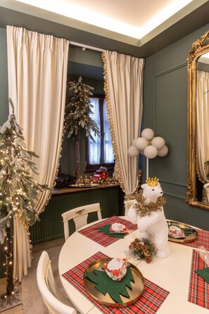 A dining area with a round table set for four, decorated with plaid placemats and a centerpiece featuring a white bear with a crown. - Rock Dandy La Maison De L’Ours | Top Fireplace Retreat (Amyntaio)