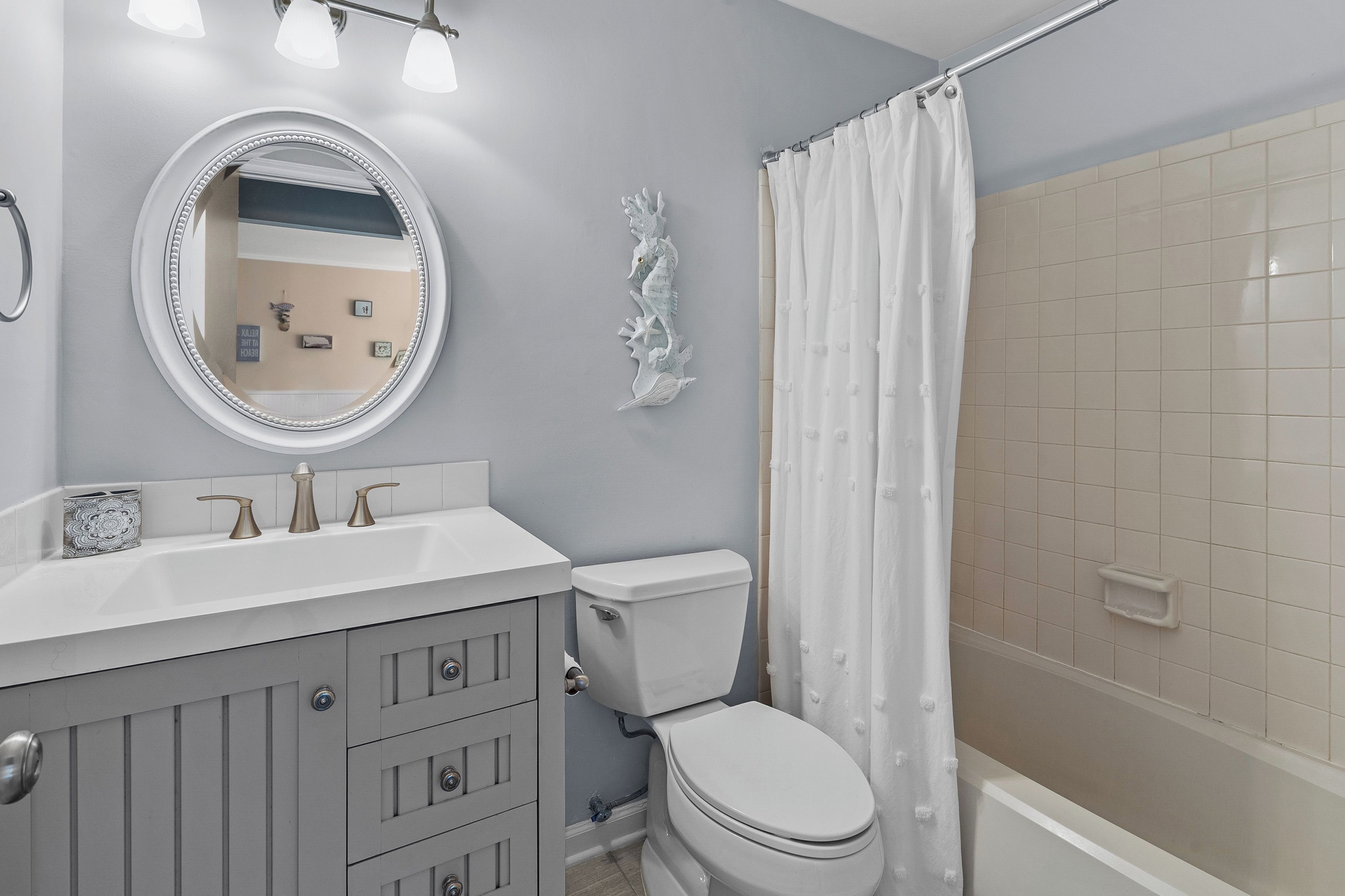 Un baño con inodoro, lavabo y cortina de ducha.
