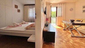 Ein modernes Schlafzimmer mit Bett, Nachttisch und Blick ins Freie.