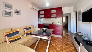 Ein modernes Apartment mit Wohnzimmer, Küche und Essbereich.