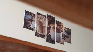 En vägg med tre inramade fotografier som föreställer kaffe och bakverk.