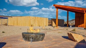 Un hogar en un patio con cerca de madera y pérgola de madera.