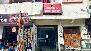 A two-story building with a storefront labeled "Milestone Homestay" and a Coca-Cola sign. - Milestone Homestay Agra (Agra)