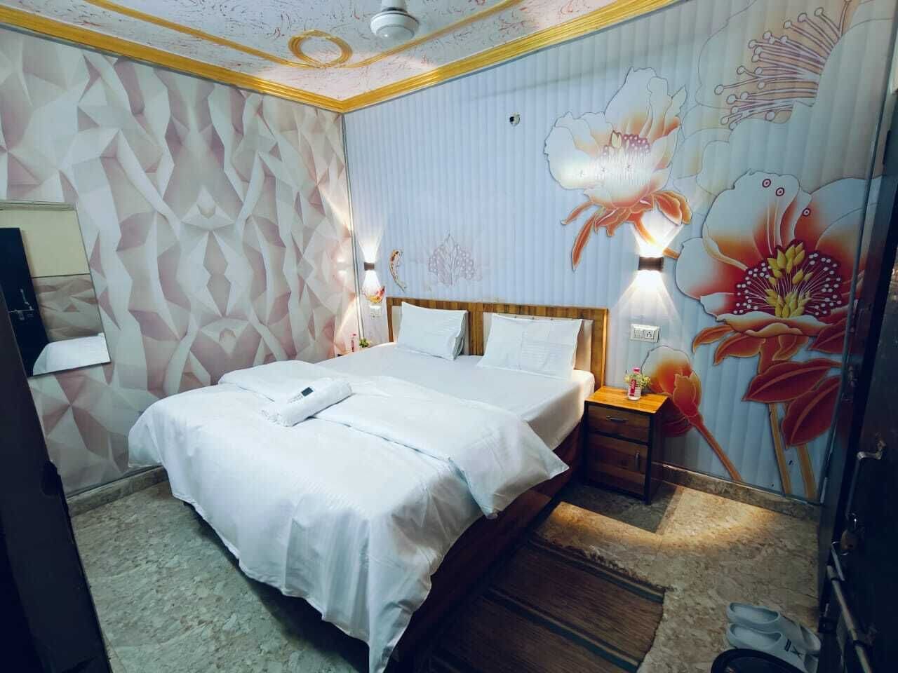 A hotel room with a bed, nightstands, and a wall mural.