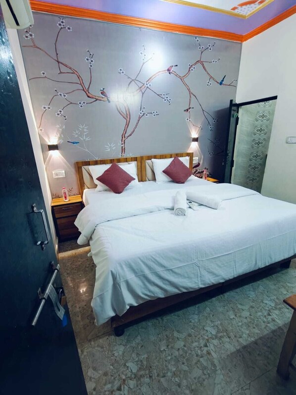 A hotel room with a bed, a nightstand, a wall mural, and a door. - Milestone Homestay Agra (Agra)