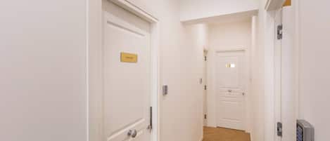 A hallway with white doors, one labeled "VATICANO".