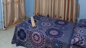 Una habitación con cama, cortinas y aire acondicionado.