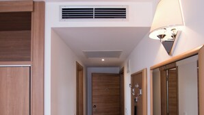 A hallway with wooden doors, a vent, and a wall-mounted lamp. - Villa Paradiso (Dubrovnik)