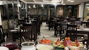 A buffet setup with various food items and a seating area with tables and chairs. - Villa Paradiso (Dubrovnik)