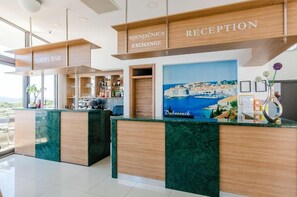A reception area with a reception desk, a lobby bar, and a view of the sea. - Villa Paradiso (Dubrovnik)