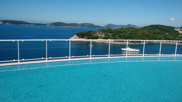 A pool with a view of the sea and a boat. - Villa Paradiso (Dubrovnik)