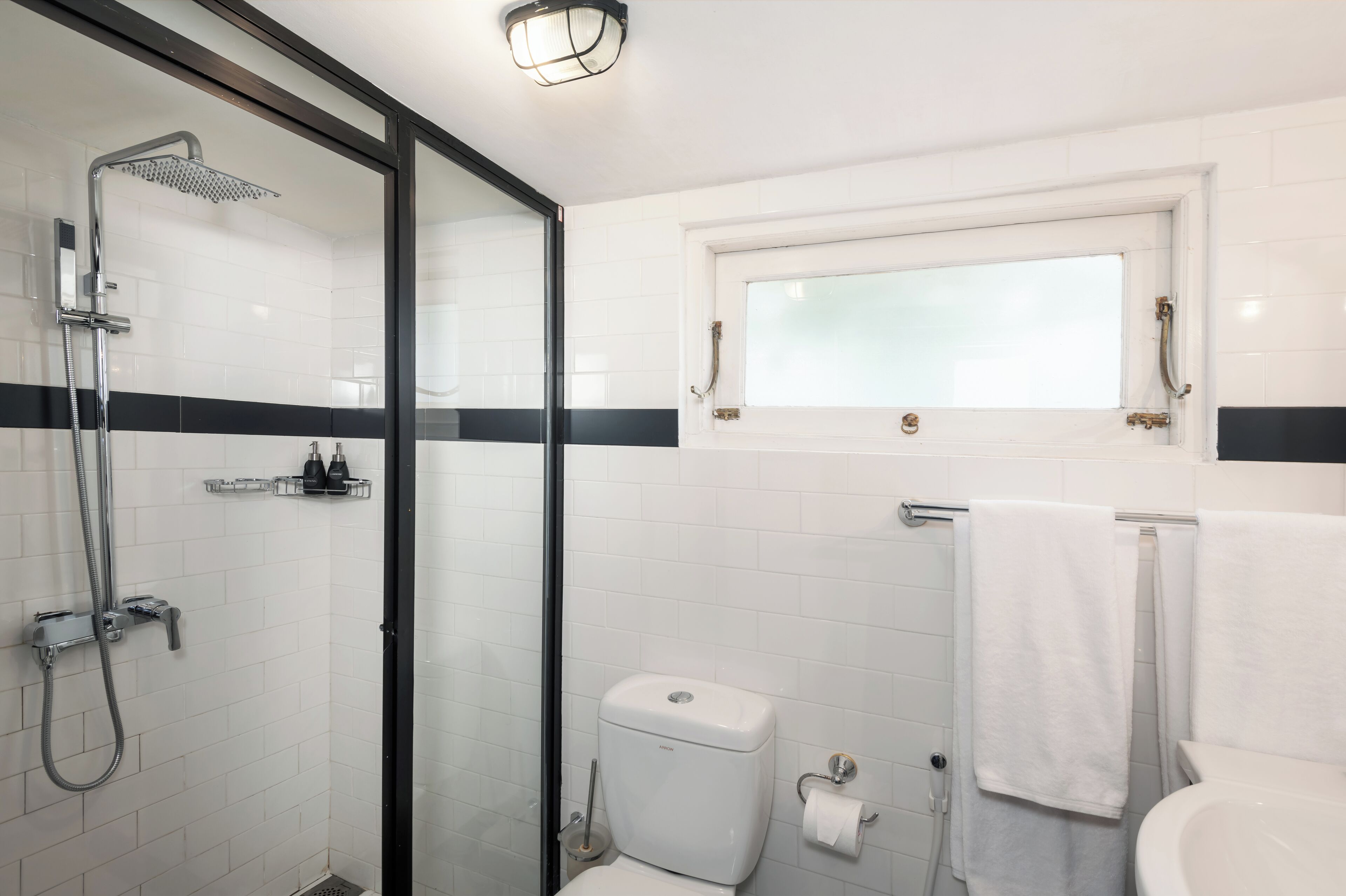 Ein modernes Badezimmer mit Duschkabine aus Glas, Toilette und Waschbecken.