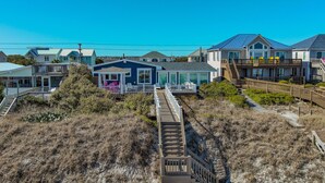 A coastal property with multiple houses, a wooden deck, and a sandy beach. - The Sandlot - Renovated & Right on the Beach! (Topsail Beach)