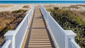 A wooden boardwalk leading to a beach with white railings. - The Sandlot - Renovated & Right on the Beach! (Topsail Beach)