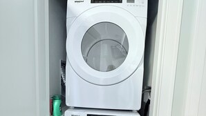 A compact laundry room with two stacked Whirlpool washing machines. - Cozy Peaks & Waters: family-friendly, kitchen, near golf, hiking & fishing (Kent)