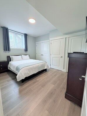 Un dormitorio con una cama, un armario y una cómoda.