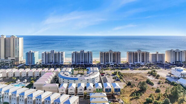 A coastal hotel area with multiple high-rise buildings, a pool, and a beach in the background. - 🌞Low Density | Community Pool | Sea Breeze 203🌞 (Gulf Shores)