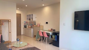 A modern kitchen with a dining table, chairs, and a refrigerator. - SURIHOME- Vinhomes Grand Park Apartments (Ho Chi Minh City)
