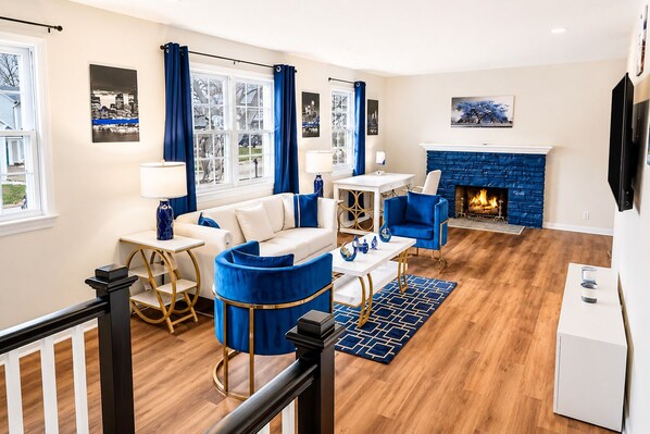 A living room with a fireplace, a sofa, a coffee table, and a TV.