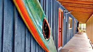 Fileira de cabanas com deck de madeira e galeria coberta.