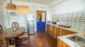A kitchen with wooden cabinets, a white countertop, and a stainless steel sink. - Monratino The Snow roost (Darjeeling)