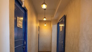 A hallway with wooden flooring, blue doors, and pendant lighting. - Monratino The Snow roost (Darjeeling)