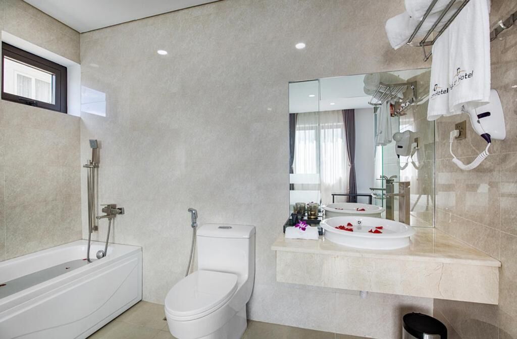 Een moderne badkamer met een badkuip, toilet en wastafelmeubel.
