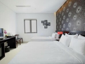 Deluxe driepersoonskamer | Luxe beddengoed, een minibar, een bureau, een laptopwerkplek