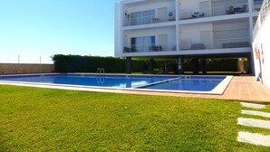 A modern multi-story building with a swimming pool in the foreground.