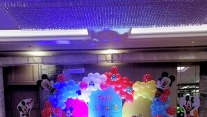 A decorated event space with balloons, a 'Tej's LA HOUSE' sign, and illuminated '1 TEJ' letters.
