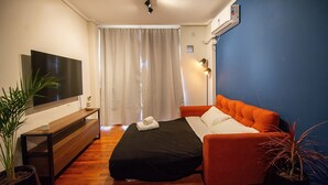 A modern hotel room with a bed, a TV, a plant, and a window with curtains. - Hornera Coti - Modern, comfortable, ideal location. (Rosario)