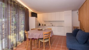 A compact living space with a dining area, kitchenette, and a sofa. - Peace in the nature close to Palazzo Vertemate, Madesimo and Engadina. (Lombardia)