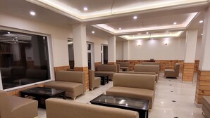 A modern lounge area with sofas and tables, a large window, and a brick accent wall. - Faagu Peaks (Theog)