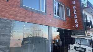 A modern building with a large glass entrance and a sign reading "FAGUPEAKS". - Faagu Peaks (Theog)