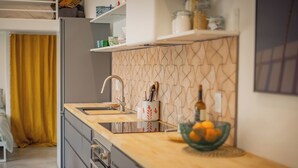 Une cuisine moderne avec un plan de travail en bois, un évier et une bouteille de vin posée sur le plan de travail.
