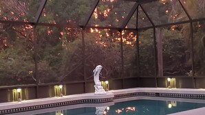 A pool with a statue in the center, surrounded by a covered area with decorative lights. - Butterfly House, close to beaches, restaurants, live entertainment & shopping (Sarasota)