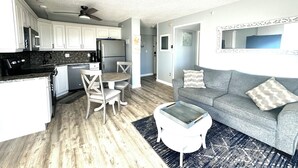 Un espacio habitable compacto con cocina, comedor y sofá.