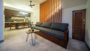 A modern living room with a sofa, coffee table, and dining area. - 3Bedroom-703-Private Pool Villa Sanur (Denpasar)