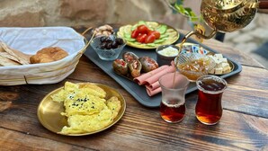 Taula amb diferents plats, incloent ous, olives i una teiera.