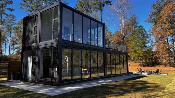 A modern glass house with a flat roof, surrounded by a grassy area and trees. - Hacker House - Do Your Best Work (LaGrange)