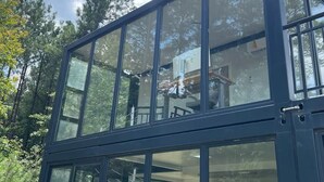 A modern glass structure with multiple levels, surrounded by trees. - Hacker House - Do Your Best Work (LaGrange)
