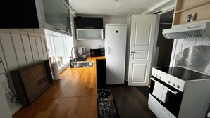 A compact kitchen with a refrigerator, microwave, sink, and stove. - Sønderborg in Denmark (Sønderborg)