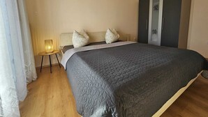 Een slaapkamer met een bed, een kledingkast, een airconditioning en een bedlamp.