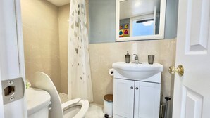 Ein kleines Badezimmer mit Toilette, Waschbecken und Duschvorhang.