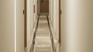 A long, narrow hallway with a reflective floor and illuminated walls. - Sky-High 70sqm Penthouse w. Stunning Views - 05

 (Chania)