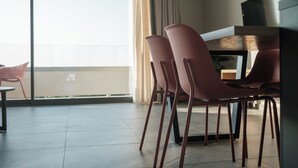 A modern dining area with a large window, a table, and four chairs. - Sky-High 70sqm Penthouse w. Stunning Views - 05

 (Chania)