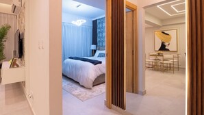 A modern hotel room with a large bed, a dining area, and a living space. - Las Mariposas 22-2F (Santo Domingo)