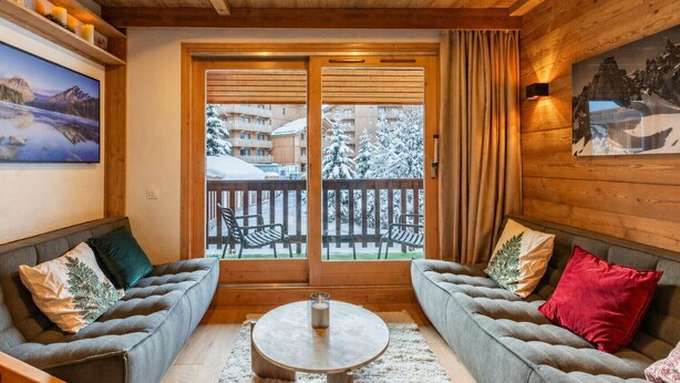 A cozy room with two sofas, a round coffee table, and a view of a snowy balcony. - Troillet 11, 200m away from the ski pistes (Les Allues)